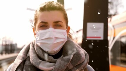 Poster - health safety, travel and pandemic concept - young woman in protective face mask at railway station in winter