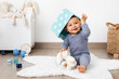 © Lisa Tichané - Smiling baby in playroom with basket on head