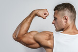 Young bodybuilder man showing his muscular arm