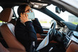 © Drobot Dean - Business woman sitting in a car in face mask