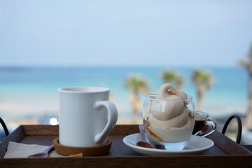 Latte and affogato in a cafe in front of a beach