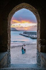 Wall Mural - couple on vacation Sicily visiting the old town of Cefalu,sunset at the beach of Cefalu Sicily, old town of Cefalu Sicilia panoramic view at the colorful village.Italy