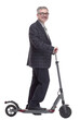 © ASDF - side view. Mature man with electric scooter looking at you
