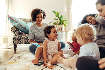 Wall Mural - Mothers looking at their babies playing