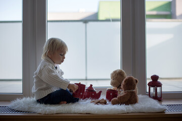 Sticker - Sweet blonde child, boy, sitting on window shield, drinking tea with teddy bear friend toy