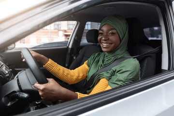 Wall Mural - Road Trip. Black Muslim Woman In Hijab Enjoying Driver Car In City