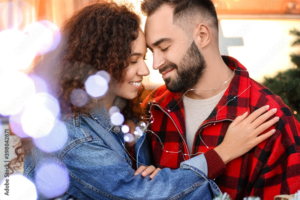Happy young couple celebrating Christmas outdoors