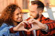 © Pixel-Shot - Happy young couple making heart with their hands outdoors