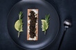 Black caviar of sturgeon in the biscuits with cream cheese. Spoon with caviar. Round blue plate. Dark background 