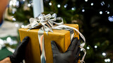 Fototapeta  - gift - christmas holiday 2020 - handing a gift with gloves