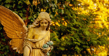 Guardian angel statue in sunlight. Free copy space for design or text. Horizontal image.