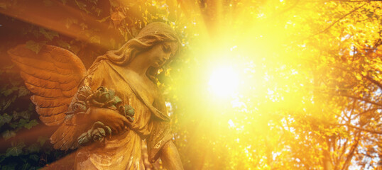 Wall Mural - Guardian angel statue in sunlight. Horizontal image.