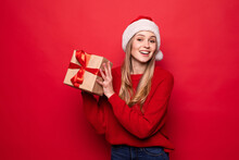 Christmas Woman Holding Christmas Gifts Smiling. Cute Beautiful Caucasian Santa Woman Isolated On Red Background