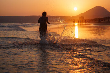 a boy running on water on sea shore, Mukalla City, Yemen, 2020