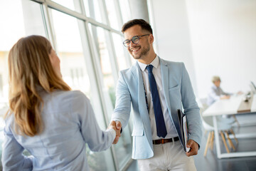 Young business partners making handshake in an office