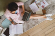 © Olena Bloshchynska - Young businesswoman sitting on floor working with documents and typing on laptop.