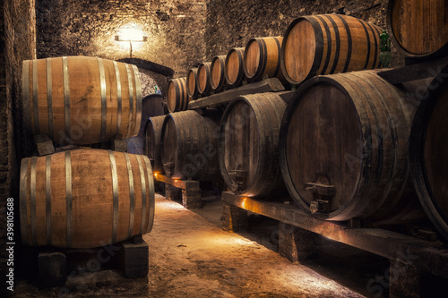 Photo Wooden barrels with wine in a wine vault