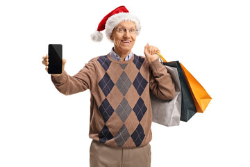 Sticker - Elderly gentleman with a christmas santa hat showing a mobile phone and holding shopping bags