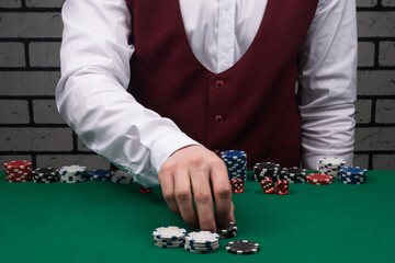 the croupier makes a poker bet on the green table cloth