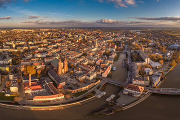 Wall Mural - A drone view of the historic city with the market square, churches, town hall and the castle tower in Opole during sunset. Autumn in Silesia - Poland.