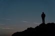 © pogina - Silhouettes of man  on top of a mountain.
