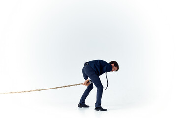 Poster - business man with a rope in his hands on a light background tension model of achieving the goal