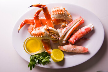 Wall Mural - King crab or Dungeness legs . Jumbo Crab served with lemons, spicy rémoulade sauce on top of a mixed green salad. Classic American restaurant or steakhouse appetizer or entree.