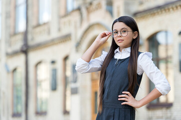 Wall Mural - Little child in uniform with back to school look fix eyeglasses to correct sight, eyecare, copy space