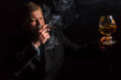 © idea_studio - Solid confident bearded man in suit with glass of whisky and cigar with fume