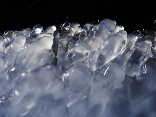 stunning frozen icicles waterfall on a rocky mountain cliff on a winter day. the winter cascade is f