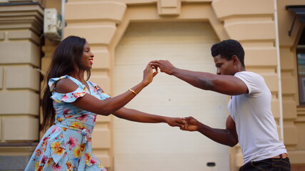 Wall Mural - African american dancers dancing outdoors. Couple moving in latino dance in city