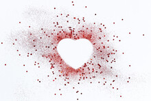 Red Confetti Glitter In Shape Of Heart On White Festive Background, Copy Space, Valentines Day Holiday Festive Card