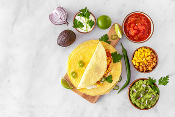 Tortilla wrap or burrito with corn, beans, greens, and homemade guacamole.