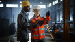 © Gorodenkoff - Two Heavy Industry Engineers Stand in Steel Metal Manufacturing Factory, Use Digital Tablet Computer and Have a Discussion. Black African American Industrial Specialist Talk to Female Technician.
