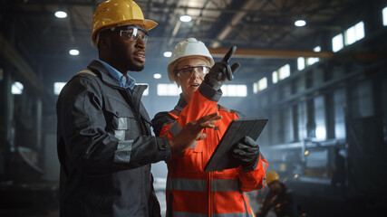 Aufkleber - Two Heavy Industry Engineers Stand in Steel Metal Manufacturing Factory, Use Digital Tablet Computer and Have a Discussion. Black African American Industrial Specialist Talk to Female Technician.