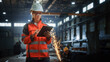 © Gorodenkoff - Professional Heavy Industry Engineer/Worker Wearing Safety Uniform and Hard Hat Uses Tablet Computer. Serious Successful Female Industrial Specialist Standing in a Metal Construction Manufacture.