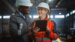 © Gorodenkoff - Two Heavy Industry Engineers Stand in Steel Metal Manufacturing Factory, Use Digital Tablet Computer and Have a Discussion. Black African American Industrial Specialist Talk to Female Technician.