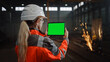 © Gorodenkoff - Professional Heavy Industry Engineer Uses Tablet Computer with Green Screen Mock Up Display. Female Industrial Specialist Working in a Metal Manufacture Warehouse with Sparks in the Background.