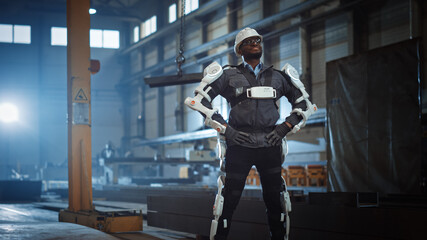 Poster - Black African American Engineer is Testing a Futuristic Bionic Exoskeleton and Proudly Posing in Heavy Steel Industry Factory. Powered Mobile Machine Shell made for Helping Workers.