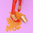 © Porechenskaya - Fast Food creative concept. Minimal art. Legs  in red patent leather pants and shoes with corn cheese rings. Home party trash fashion style