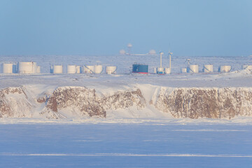 Wall Mural - winter arctic industrial landscape. view of wind turbines and tanks for fuel and oil products on a h