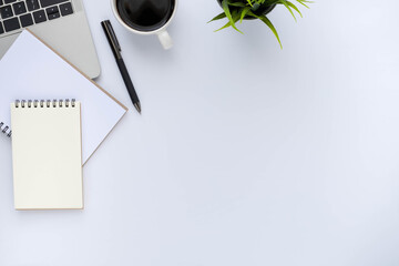 Top view above of White office desk table with keyboard laptop, notebook and coffee cup with equipment other office supplies. Business and finance concept. Workplace, Flat lay with blank copy space.