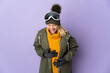 © luismolinero - Skier Russian girl with snowboarding glasses isolated on purple background smiling a lot