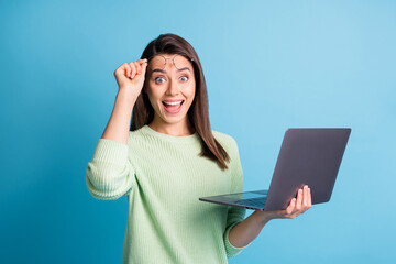 Wall Mural - astonished girl hold laptop scream unbelievable raise specs wear green jumper isolated on blue color
