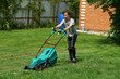 Boy mowing the lawn with lawnmower