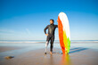 © Mangostar - Confident handicapped man standing on sea beach with board. Attractive brunette man with artificial leg wearing black wetsuit and looking at ocean. Physical disability and extreme sport concept