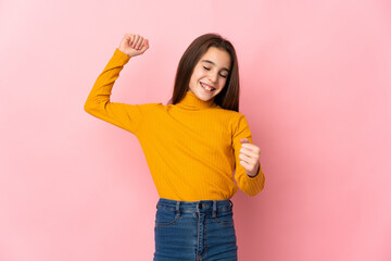 Little girl isolated on pink background celebrating a victory