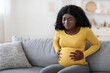 © Prostock-studio - Black pregnant woman suffering from labor pains at home