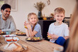 © Monkey Business - Family Sitting Around Table At Home In Pyjamas Enjoying Brunch Together