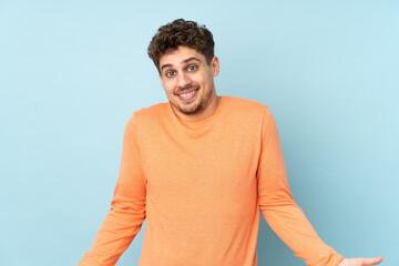 Wall Mural - Caucasian man isolated on blue background smiling